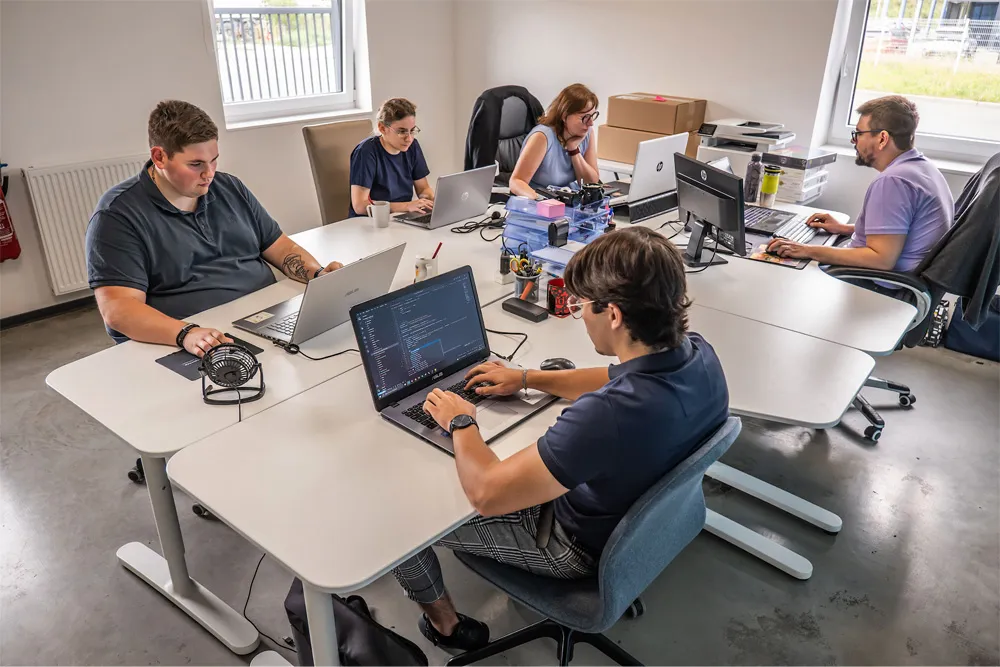 Photo d'une équipe travaillant sur des postes informatiques